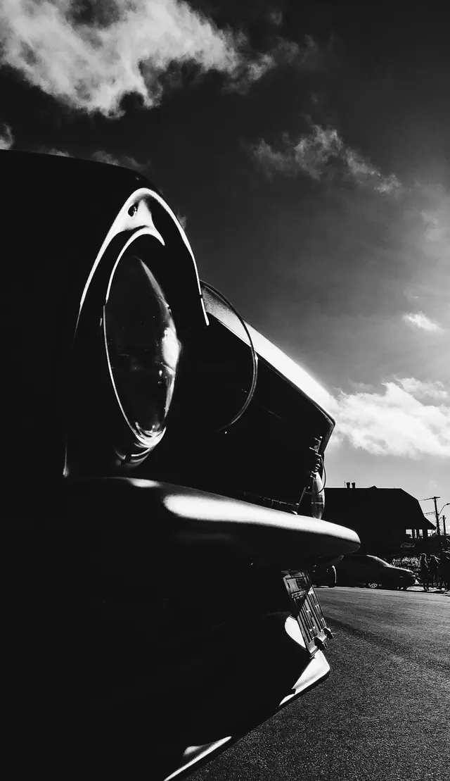 Classic car headlight in dramatic B&W, minimal, monochrome, dark