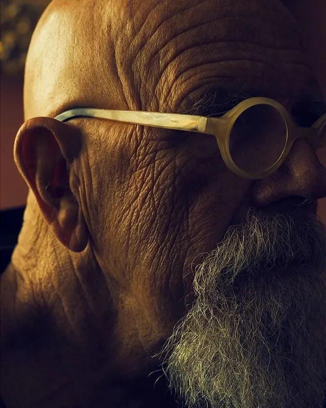 Elderly man portrait with round glasses, minimal, photographic, warm