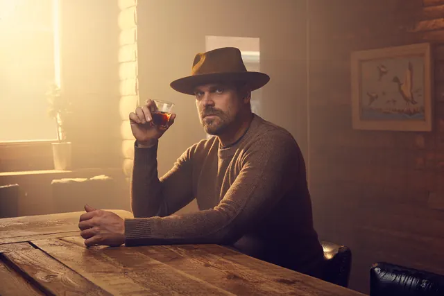 Man in Hat at Wooden Desk