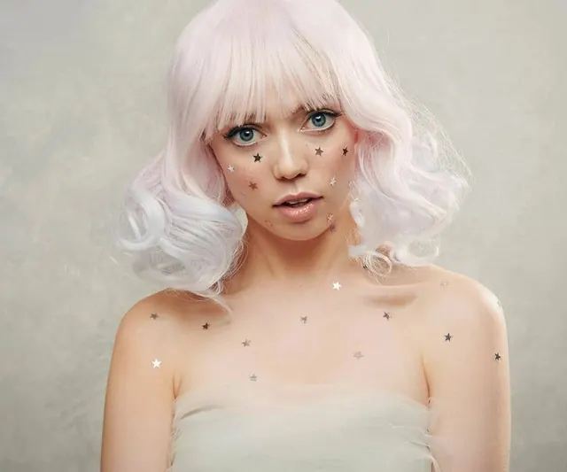 Portrait with pastel pink wig and star makeup, photographic, playful, pastel
