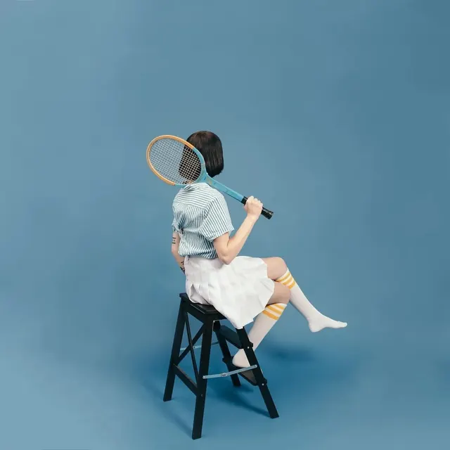 Person with Tennis Racket on Blue Background