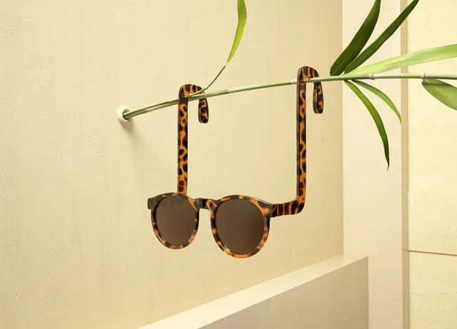 Tortoiseshell sunglasses on plant rod, photographic, lifestyle, warm