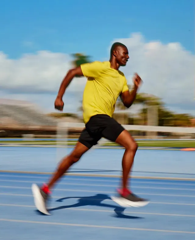 Runner in motion on blue track, photographic, bold, vibrant