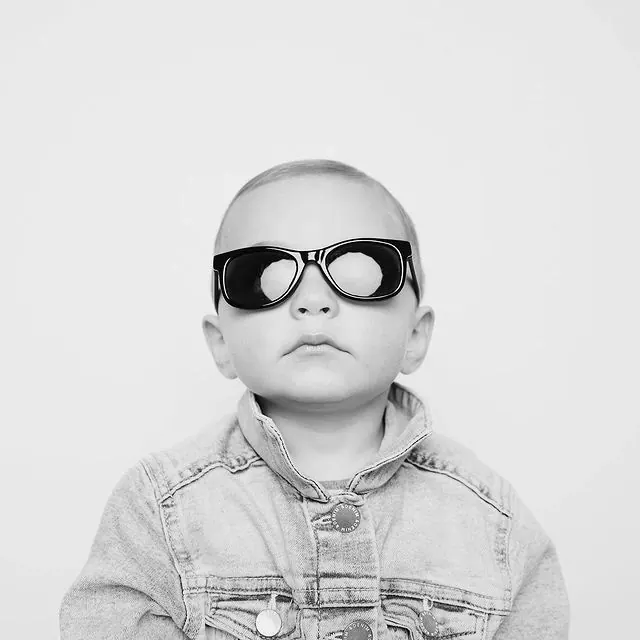 Baby with oversized sunglasses, photographic, playful, light