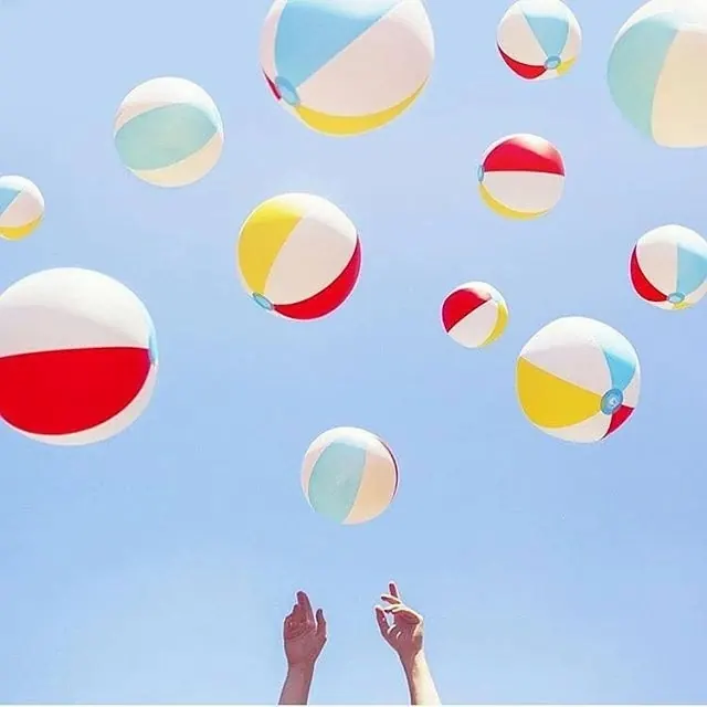 Colorful inflatable beach balls flat lay, playful, minimal, pastel