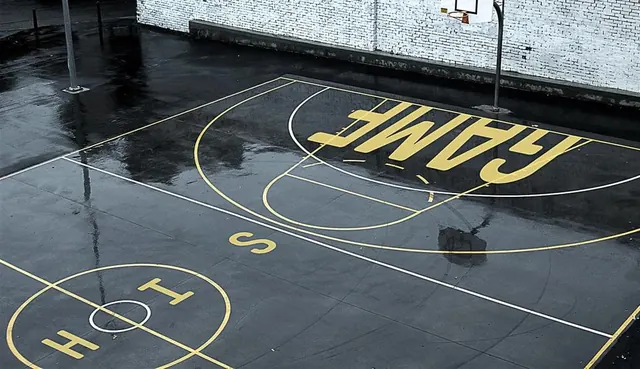 Sports court with yellow painted text and markings, technical, geometric, dark
