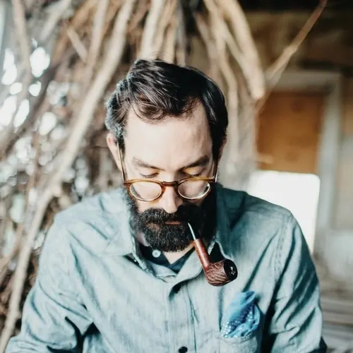 Portrait with glasses and pipe, photographic, minimal, warm