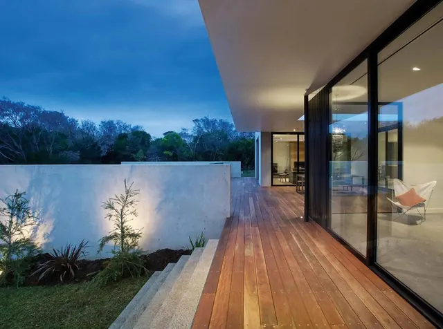 Modern residential deck and façade at dusk, minimal, photographic, warm