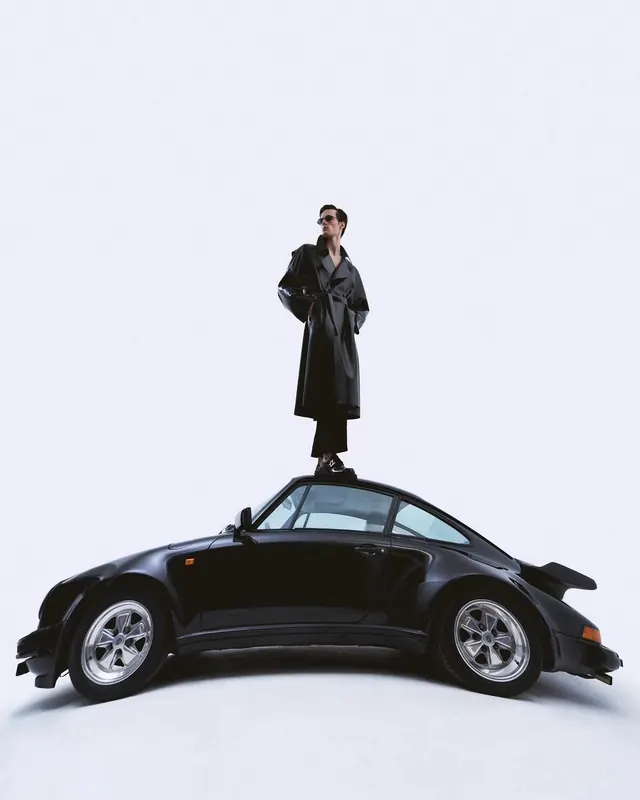 Person standing on damaged car in fashion editorial, photographic, editorial, dark