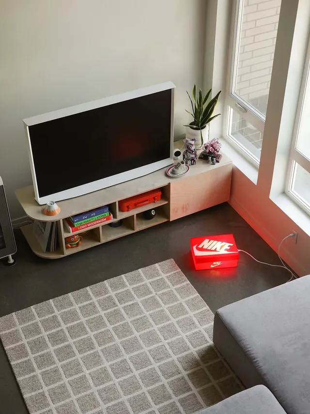 Minimal desk setup with red neon Nike sign, minimal, photographic, light