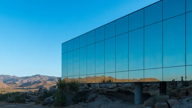 Glass building facade with mountain reflection, minimal, photographic, cool