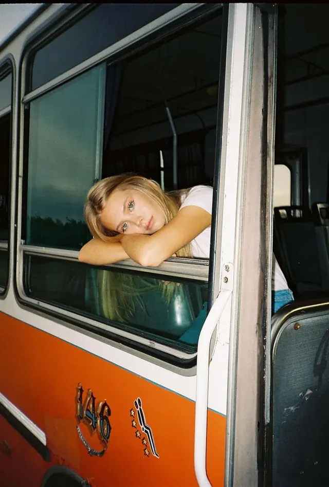 Fashion editorial portrait at vehicle window, photographic, editorial, warm