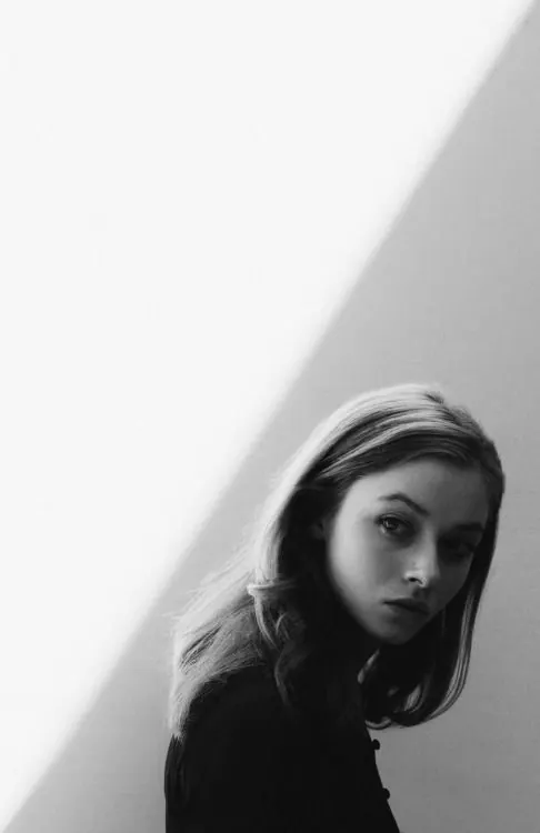 Moody black and white portrait with strong shadows, photographic, high-contrast, monochrome
