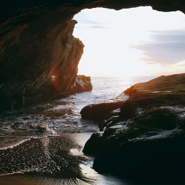 Cave seascape with golden hour light, photographic, organic, warm