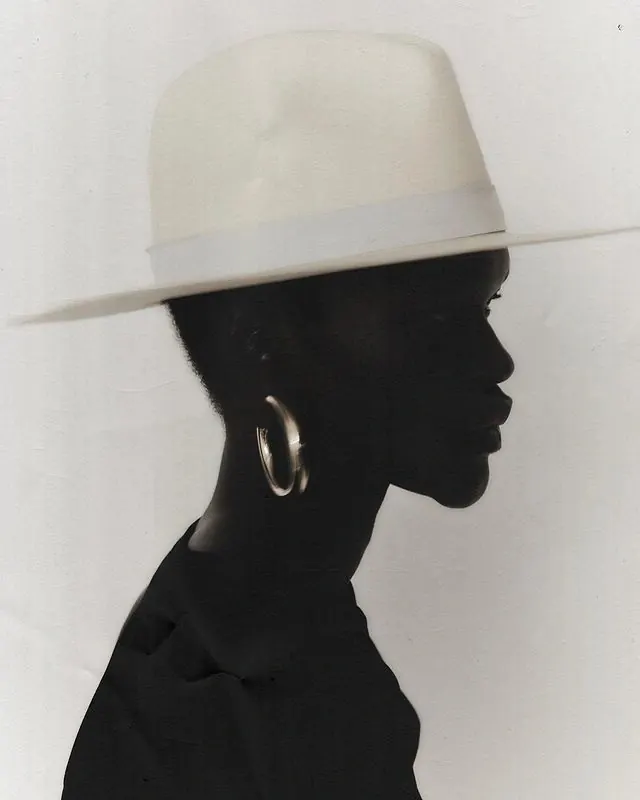 Silhouette figure in wide-brim hat, photographic, minimalist, dark