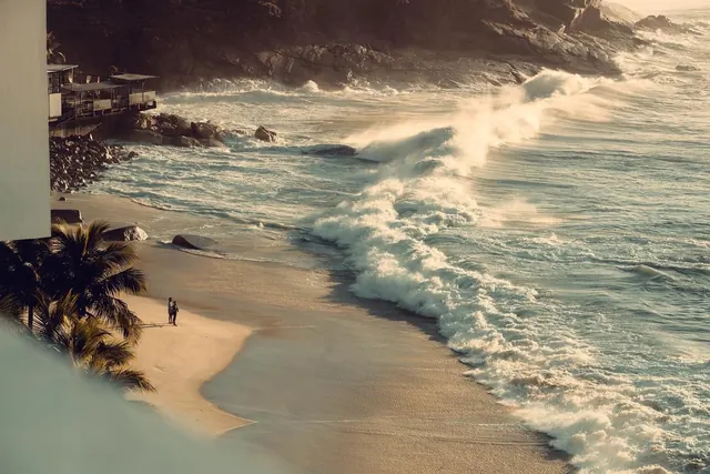 Golden-hour coastal landscape with surfer, photographic, warm, warm