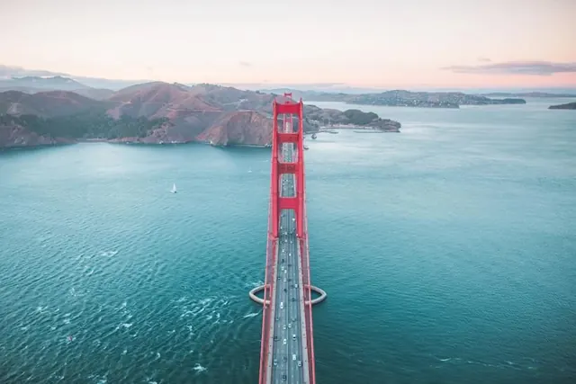 Golden Gate Bridge aerial view at sunset with turquoise water, photographic, editorial, vibrant