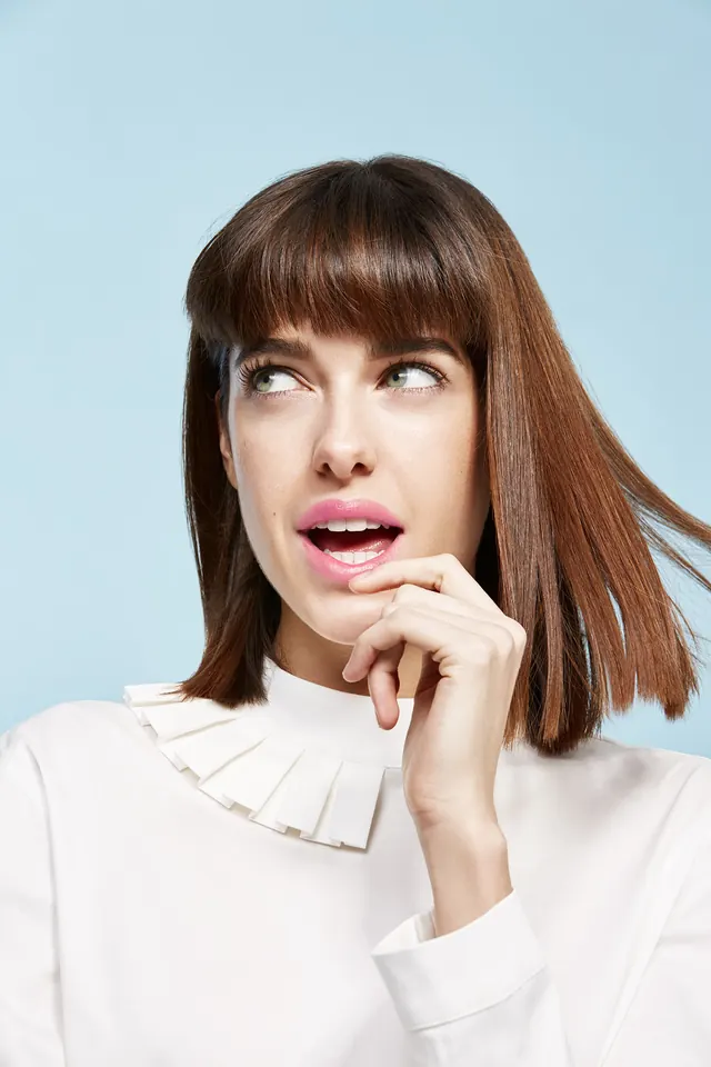 Portrait of woman with surprised expression in white collared shirt, photographic, minimal, light
