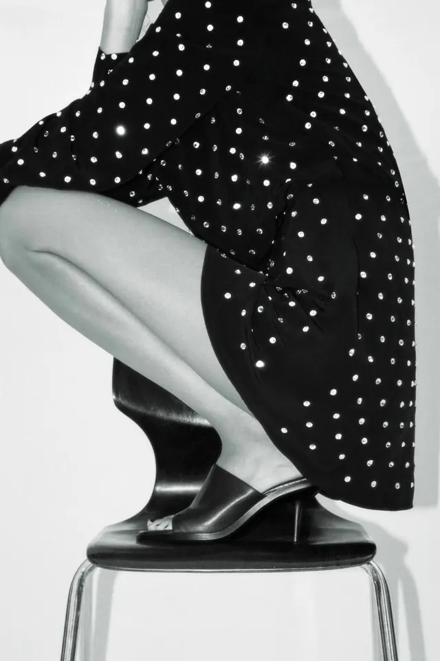 Black polka-dot garment on figure with black heels, photographic, minimalist, monochrome