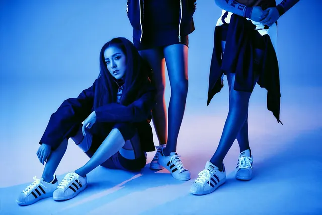 Neon-lit fashion shoot with Adidas sneakers, photographic, technical, cool