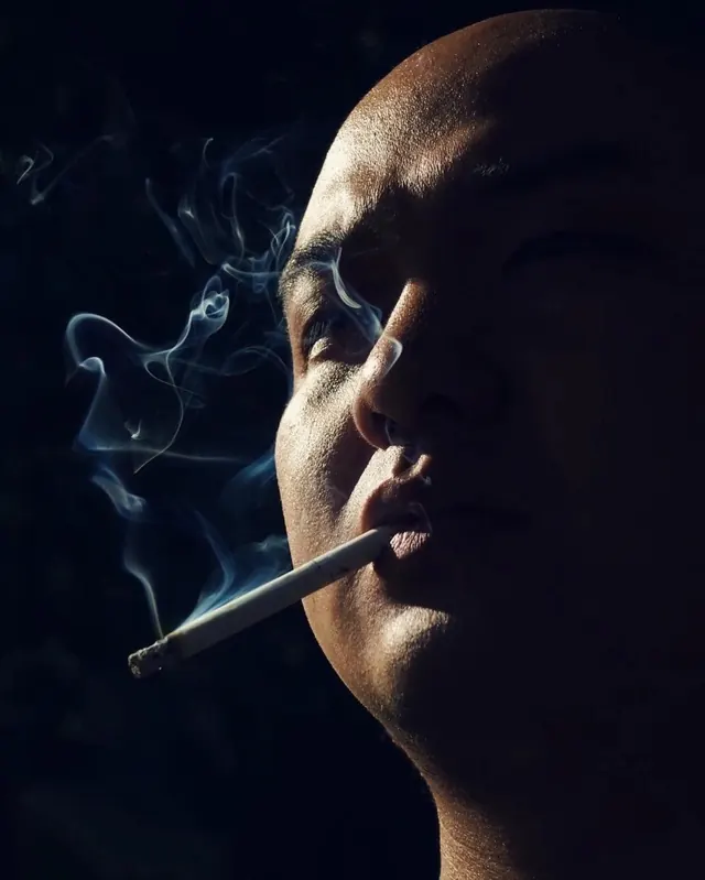 Dramatic profile portrait with cigarette and smoke, photographic, dramatic, dark