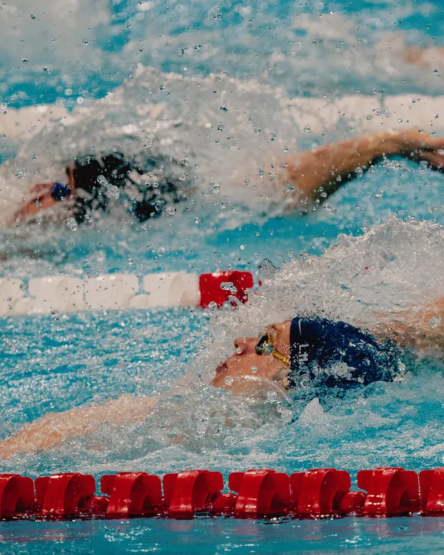 Competitive swimmers in bright turquoise pool, photographic, vibrant, vibrant