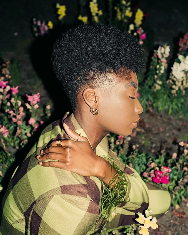 Portrait of a woman with afro hair and plaid garment