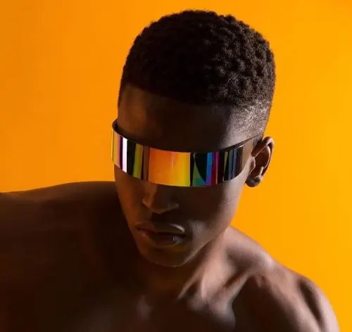 Man with rainbow visor sunglasses on orange, photographic, minimal, vibrant