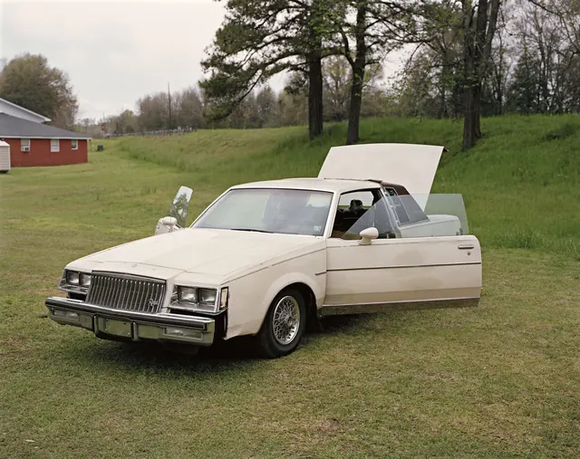 Vintage White Sedan in Field