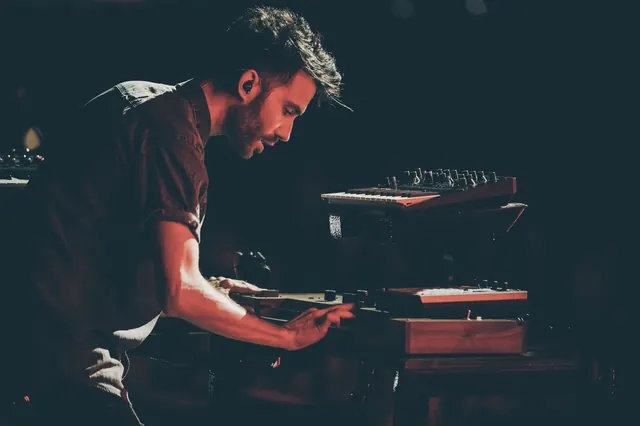 Keyboardist performing with stage lighting, photographic, dark-mode, dark