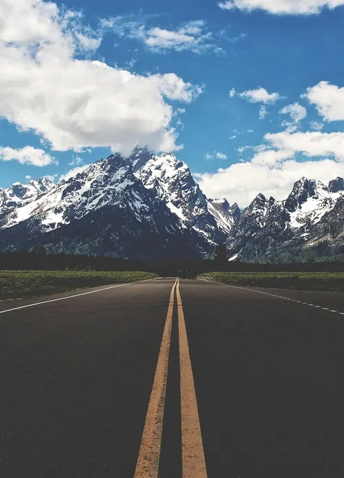 Desert highway vanishing point toward snow mountains, photographic, cool