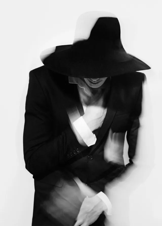 Silhouette figure in black suit and hat, dark-mode, photographic, dark