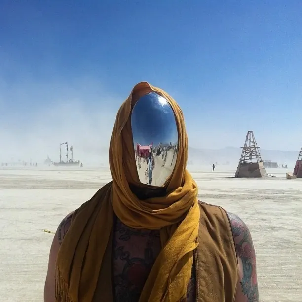 Figure with mirrored sphere reflection in desert, photographic, surreal, cool
