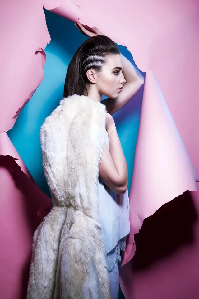 Fashion portrait with sculptural paper cutout backdrop, photographic, editorial, pastel