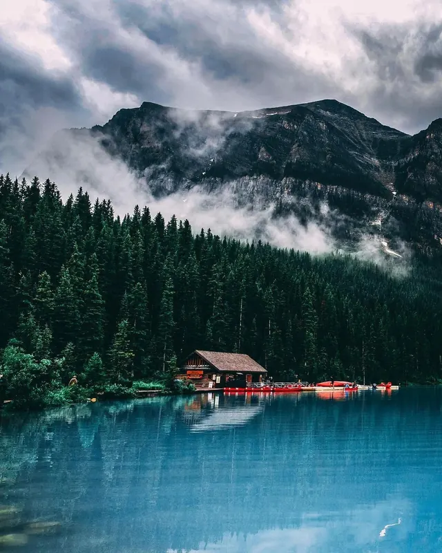 Mountain landscape with lakeside cabin and kayaks, photographic, organic, vibrant