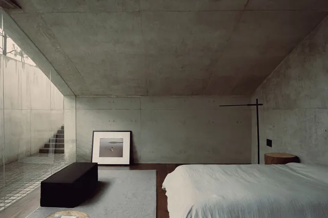 Minimalist bedroom with concrete and natural light, brutalist, minimal, dark