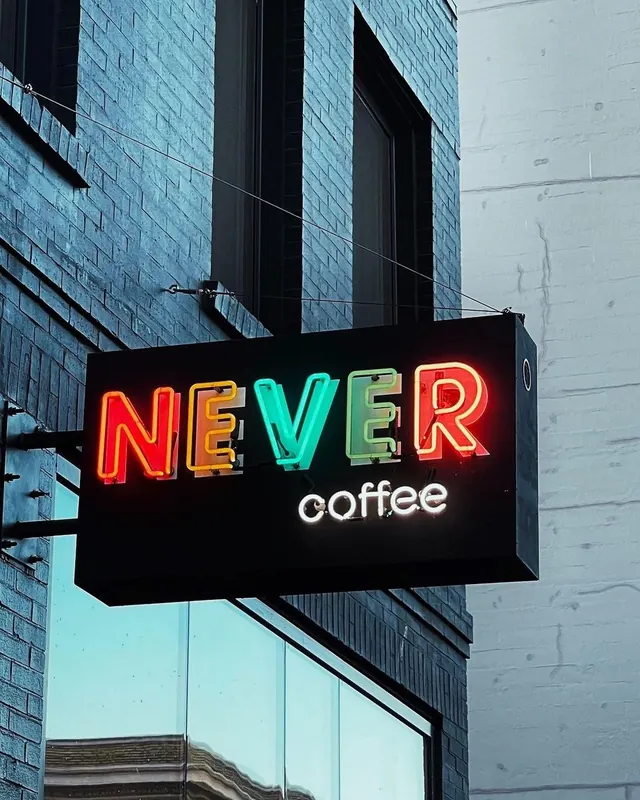 NEVER coffee neon sign on brick wall, photographic, technical, vibrant