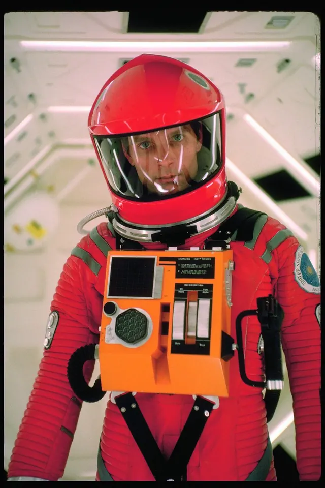 Astronaut in red spacesuit with orange control panel, photographic, retro, vibrant