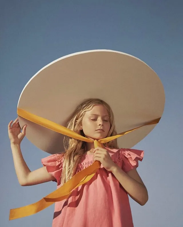Girl with large sombrero and golden ribbons, photographic, illustrative, warm