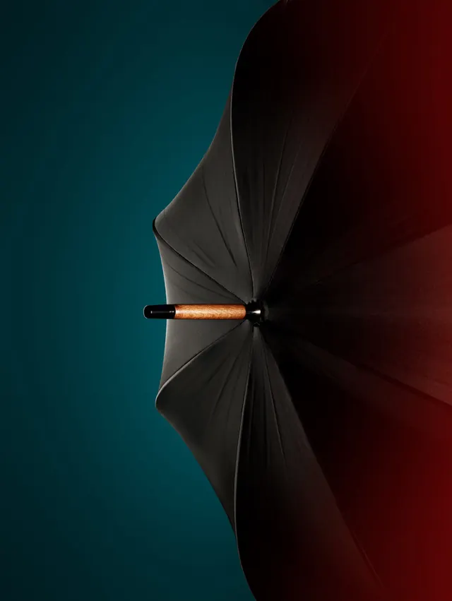 Umbrella with dramatic fabric folds against gradient background, photographic, minimalist, dark