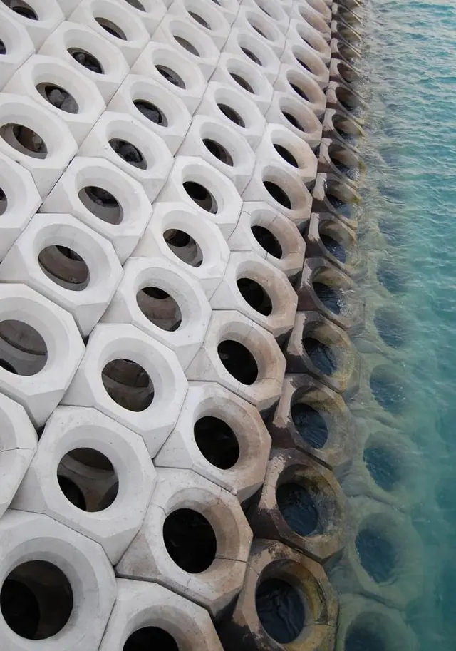 Seaside concrete breakwater with erosion, photographic, technical, light