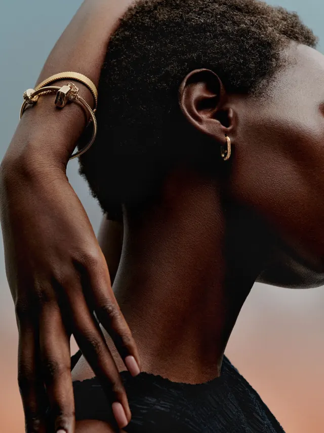Portrait with gold jewelry and neutral background, photographic, dark