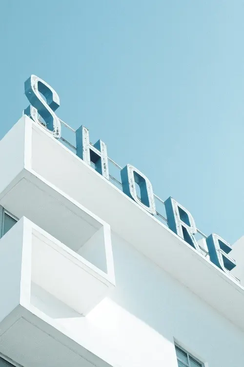 Minimalist storefront signage against sky, minimal, corporate-clean, light