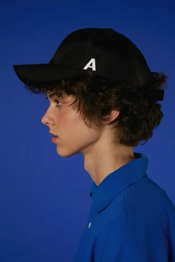 Blue-on-blue cap profile portrait, minimal, photographic, vibrant