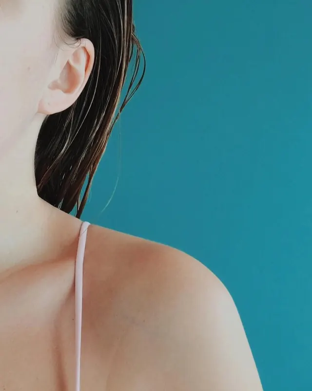 Teal background shoulder portrait crop, minimal, photographic, vibrant