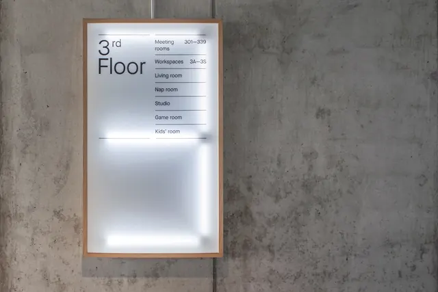 Backlit wood-frame floor directory sign, minimal, swiss, muted