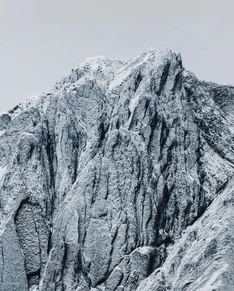 Snow-dusted mountain peak in fog, minimal, photographic, cool