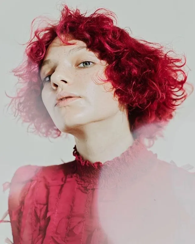 Magenta curly-hair fashion portrait, editorial, photographic, vibrant