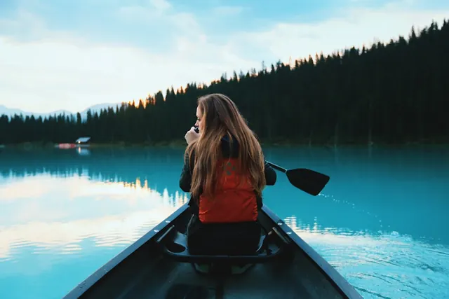 Canoe on turquoise lake at dusk, photographic, minimal, cool