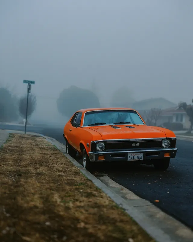 Orange Nova SS in foggy suburb, photographic, retro, vibrant